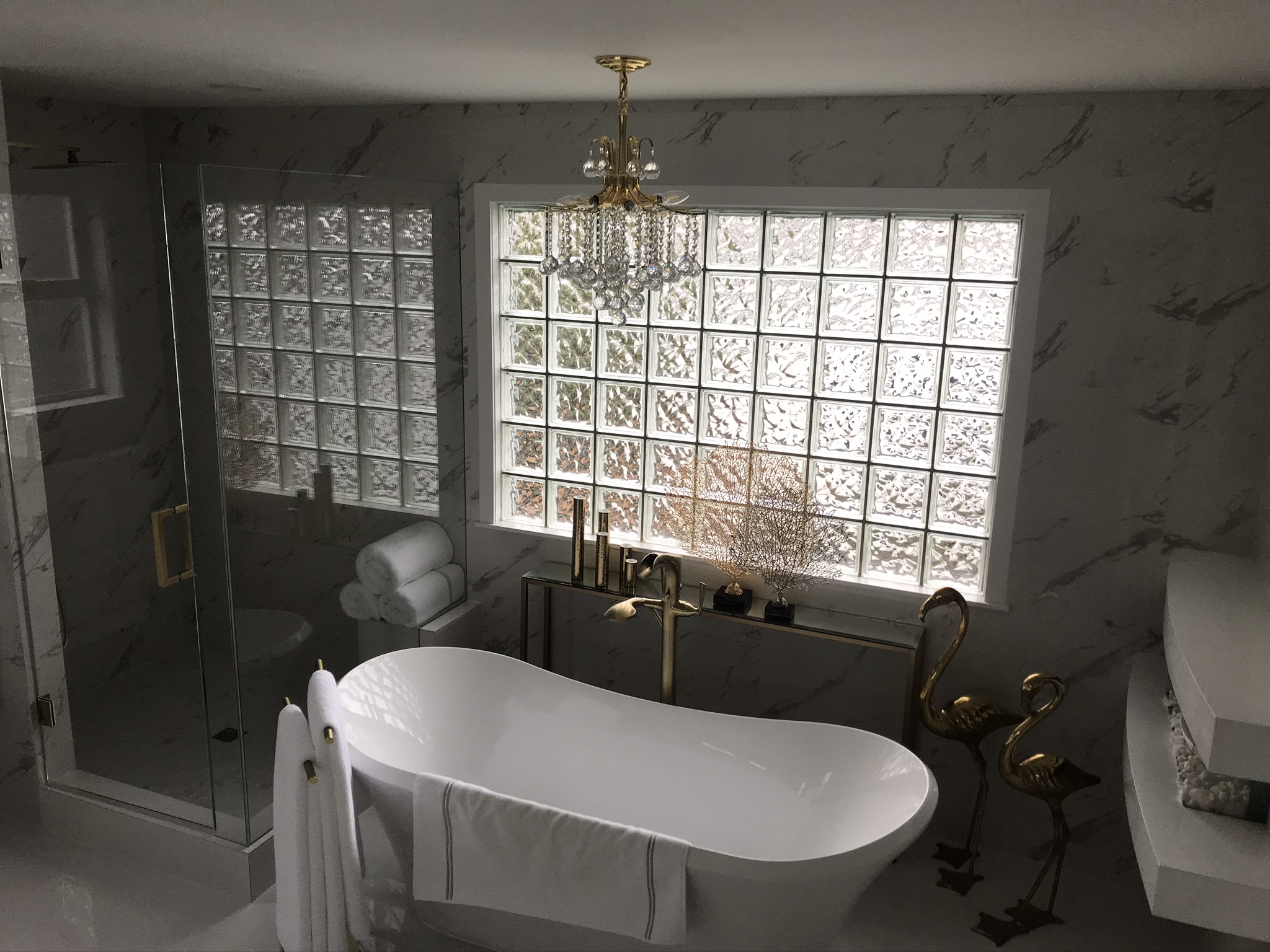 Crystal chandelier over freestanding tub in luxury marble bathroom