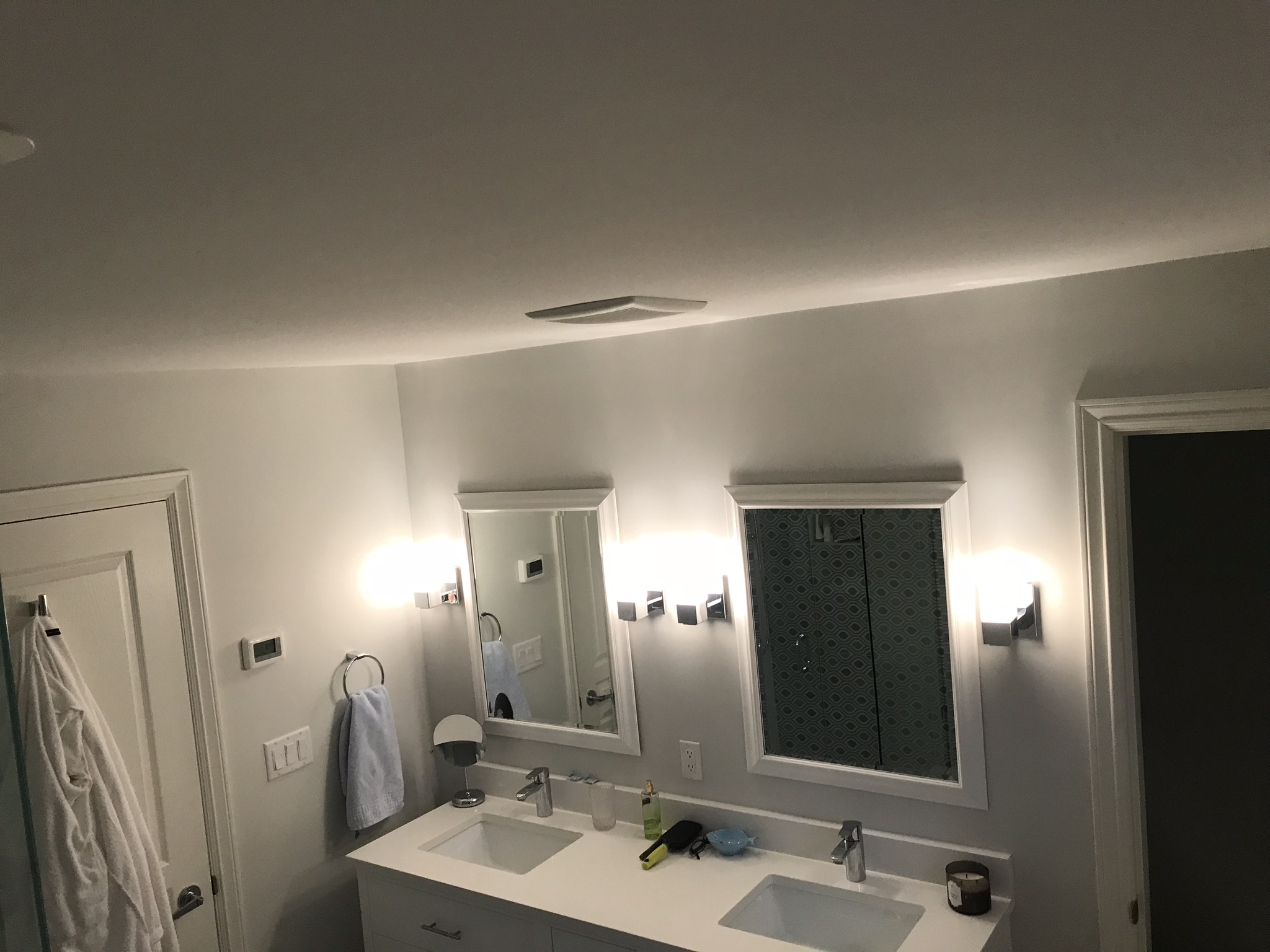 Double vanity bathroom with wall sconces flanking mirrors