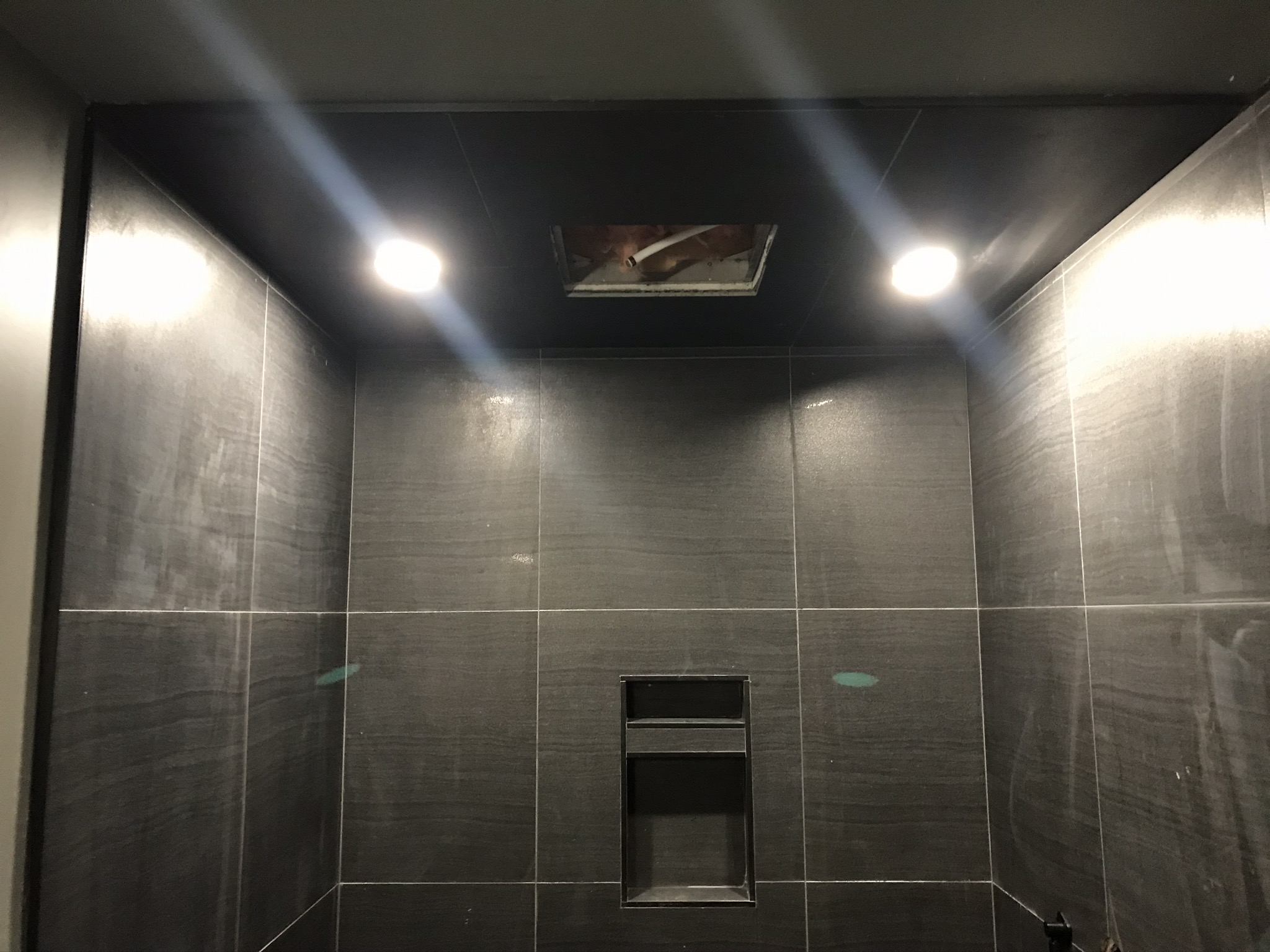 Dark shower interior with two bright recessed pot lights