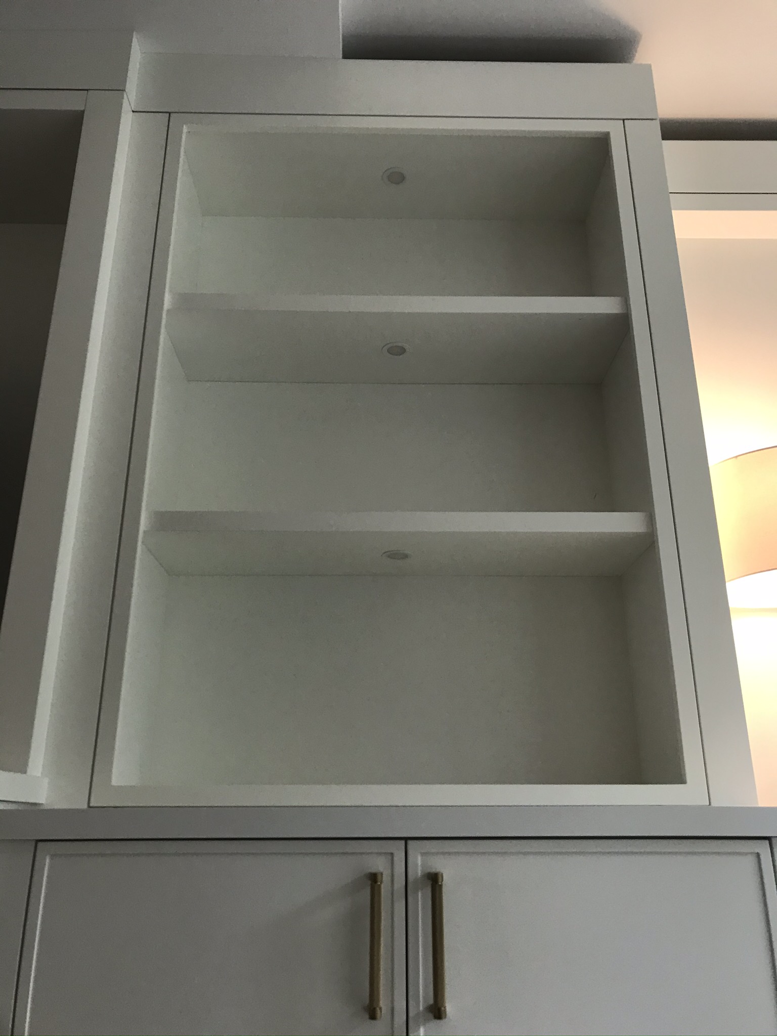 Built-in shelving with recessed puck lights on each level
