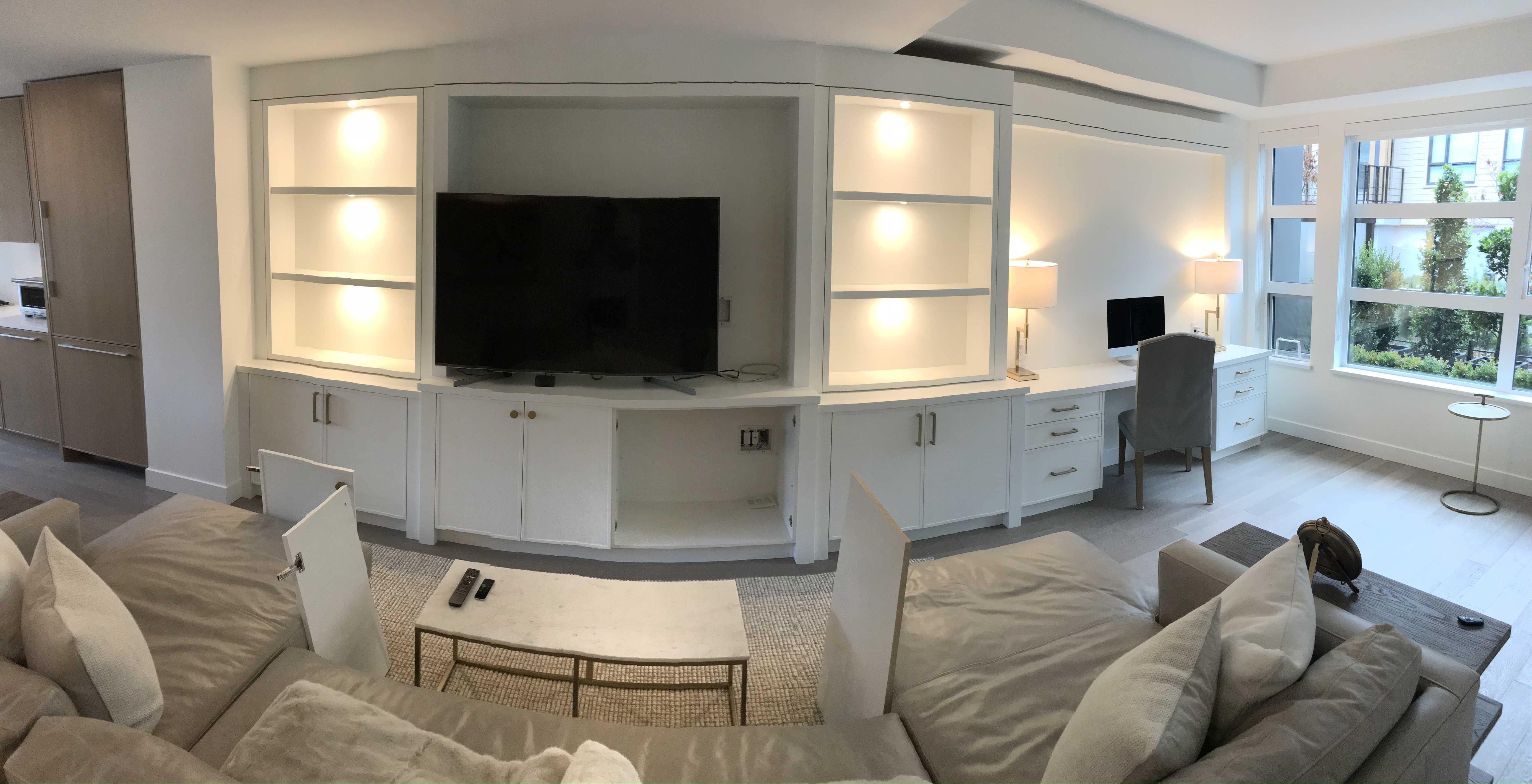Panoramic living room with built-in shelving, lit niches and TV wall