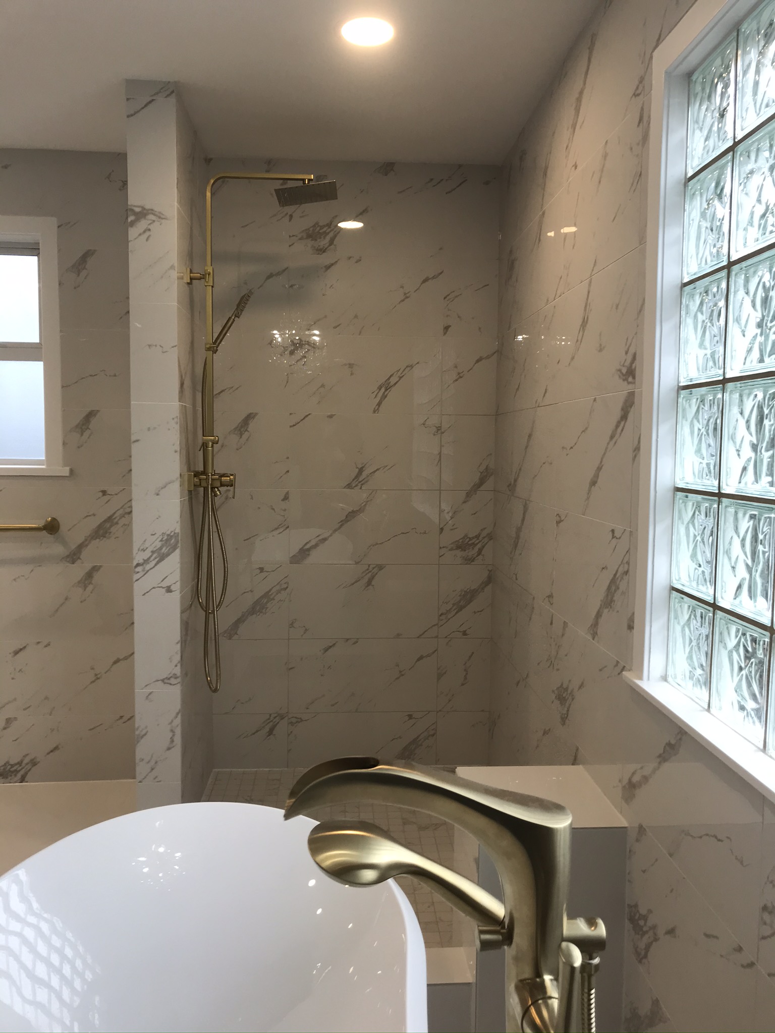 Marble shower with recessed pot light and freestanding tub